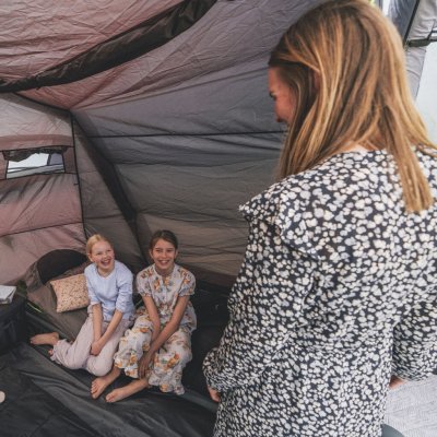 Mörklagd sovkabin och rullgardin för ventilation på familjetältet