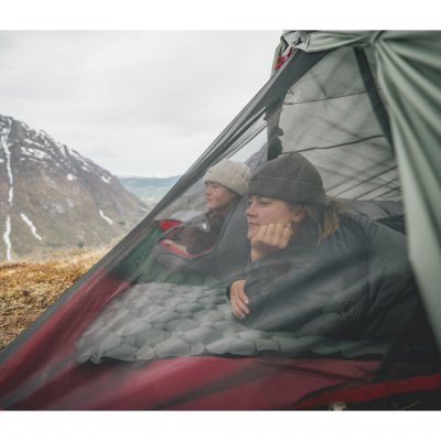 Två personer blickar ut över fjällmiljö från Robens Sprinter 2 LW tält med undanrullad ytterduk.